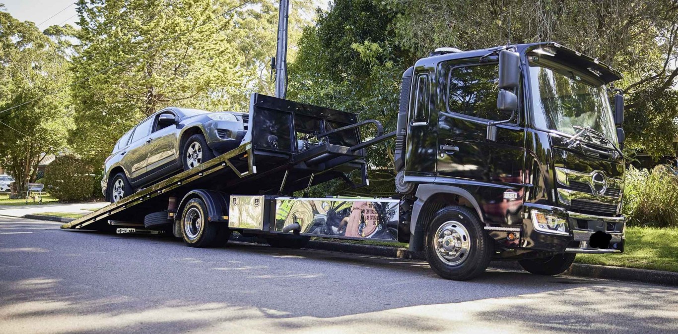Professional tow truck transporting vehicle in Lauderhill, FL