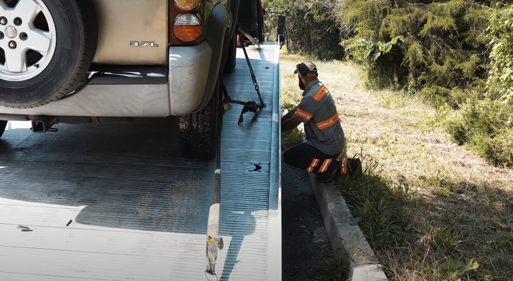 Professional flatbed tow truck securing a luxury SUV for safe transport